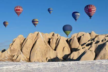 Hot-air balloons over snow-tipped rock formations in Cappadocia in Turkey. Photo: Izzet Keribar