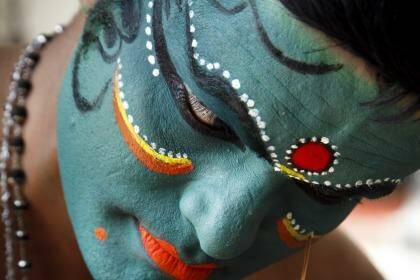 A Kathakali dancer prepares for a performance. The make-up session is one of the attractions of the event.