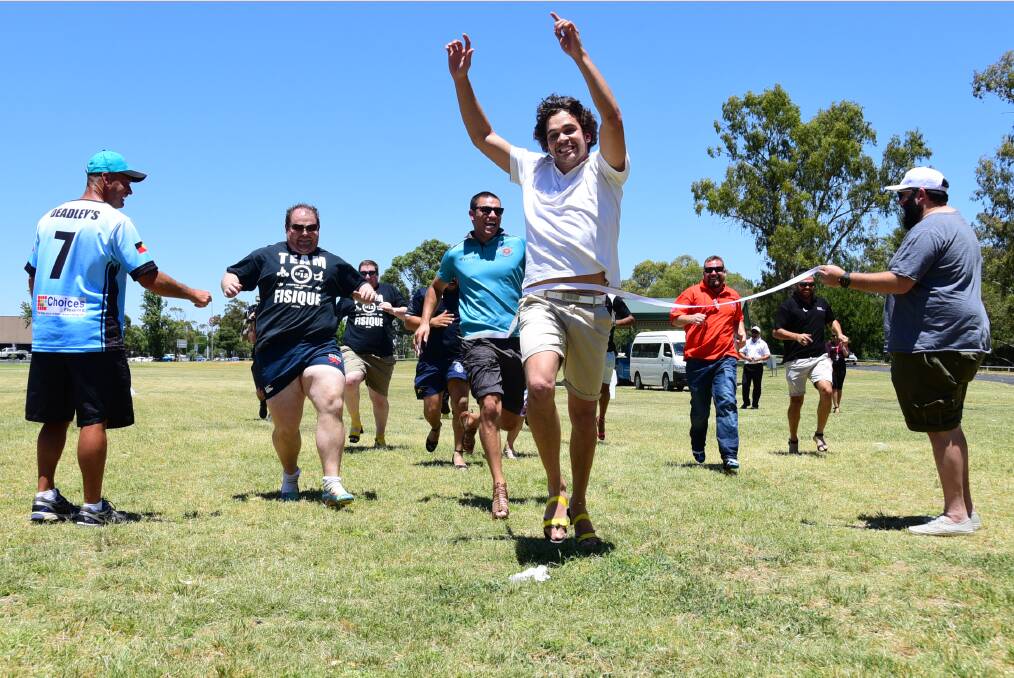 Eric Fernando crosses the finish line in first at the inaugural White Ribbon Men s High Heel Run at Ollie Robbins Oval on Wednesday. 	Photo: BROOK KELLEHEAR-SMITH