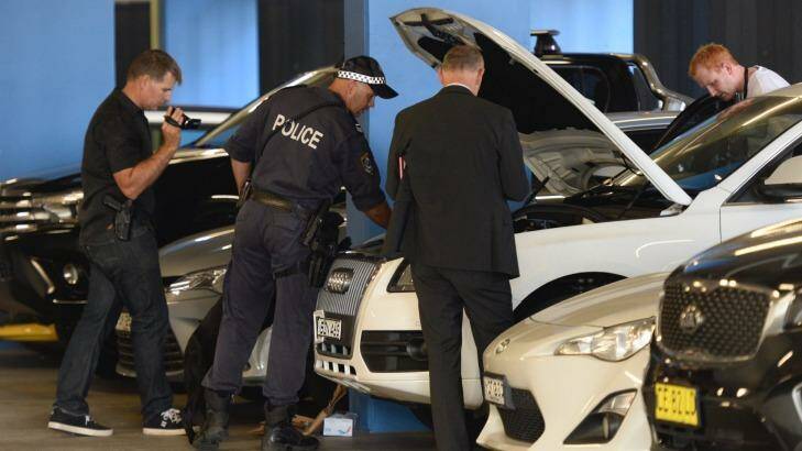 Police inspect vehicles in the carpark beneath a unit block in Australia Avenue, Olympic Park. Photo: Wolter Peeters