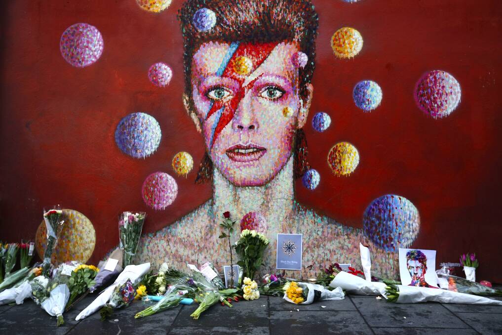 Flowers are laid beneath a mural of David Bowie in Brixton earlier this week in London  
Photo: Carl Court/Getty Images