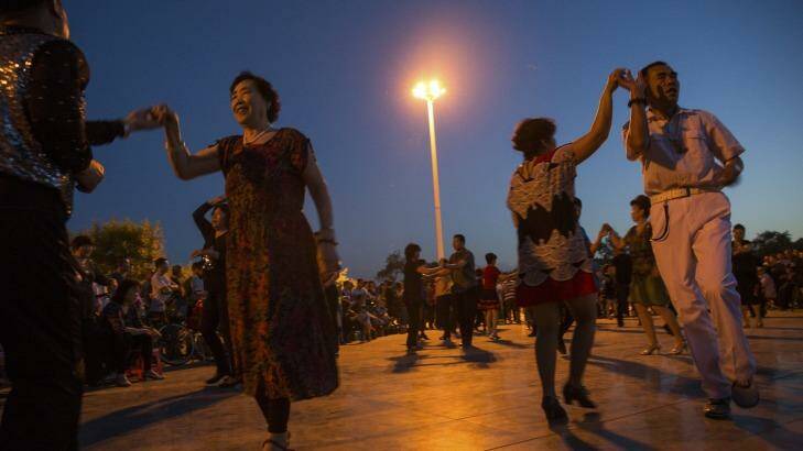 Men and women participate in a mass dance, a nightly activity in Tianjin, China. By developing 12 model routines to be taught nationwide, Chinese officials are attempting to regulate the ad hoc public dances that have become hugely popular in recent years. Photo: New York Times