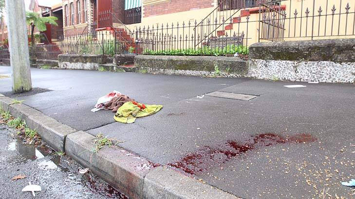 Blood stains and towels on the pavement in Jones Street, Pyrmont, where a man and his son were shot on Sunday. Photo: Peter Rae