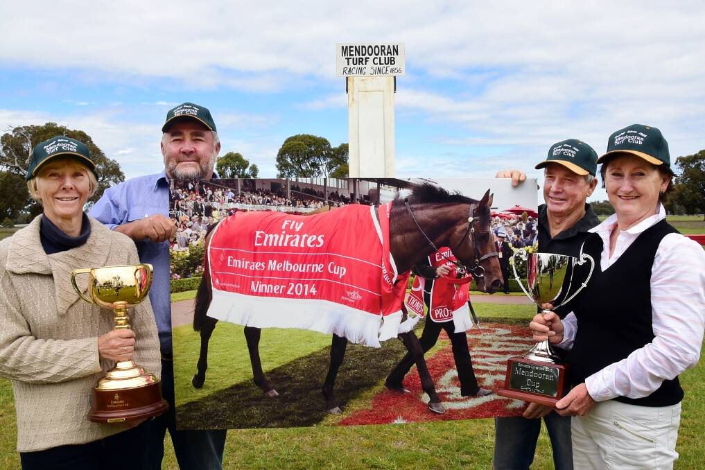 Julie Hunter holds the Melbourne Cup and Trish Langford holds the Mendooran Cup, while John Hunter and Geoff Langford show off a photo of reigning Melbourne Cup champion Protectionist.  
Photo: BELINDA SOOLE