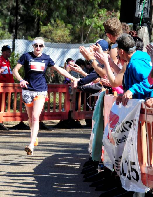 Dubbo's Jane Fardell gets the support of her home crowd as she heads towards the finish line in yesterday s Rhino Rumble.  
Photo: LOUISE DONGES