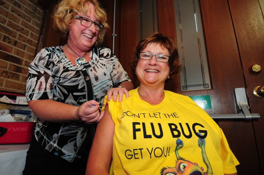 Western NSW Local Health District clinical nurse consultant immunisations and communicable disease control Carol George vaccinates its director of operations Lindsey Gough against flu.  
Photo: LOUISE DONGES