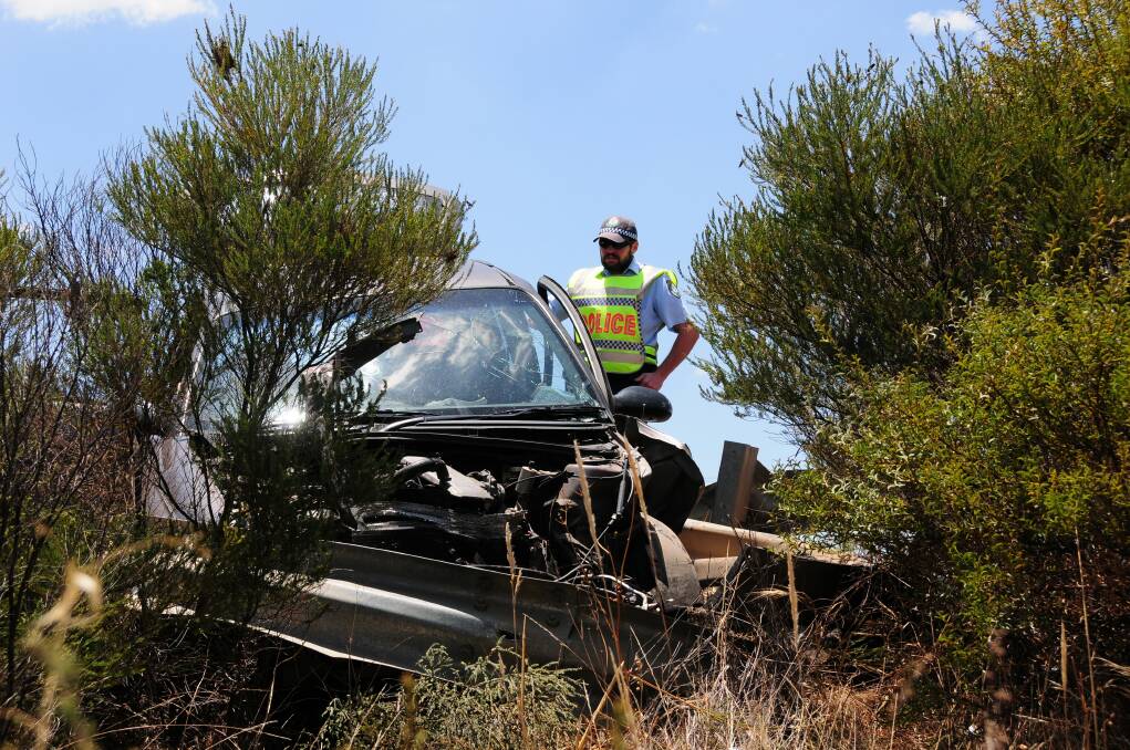 Sergeant Constable Todd Williams inspects the wreckage on the side of the Newell Highway. Photo: GREG KEEN.