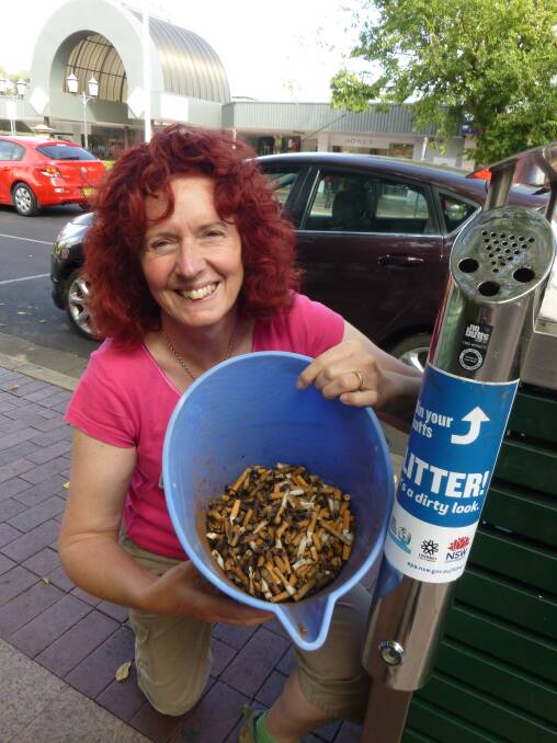 Dubbo City Council's stormwater education officer Karen Hagan shows the contents of a new bin for the disposal of cigarette butts in Macquarie Street.