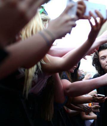 Grinning and bearing it: Harry Styles, of One Direction, is mobbed by smartphone-wielding fans at the ARIAs in Sydney.  Photo: Mark Metcalfe