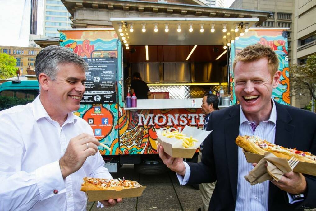 Justin Parry-Okeden and Ian Hudspith lunch on pulled pork rolls from the Monster Roll truck in Queen's Square. Photo: Dallas Kilponen