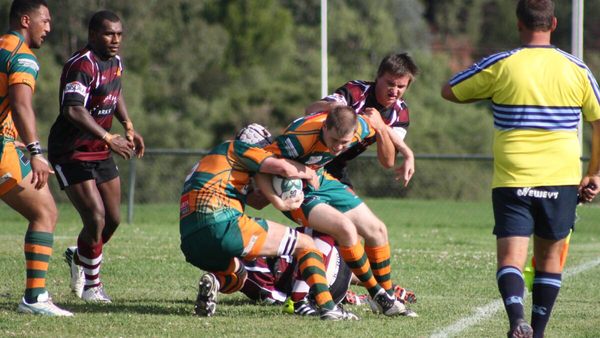 ORANGE CITY: Winger Cameron Cole is bundled up by the Parkes defence. Photo: MICHELLE COOK