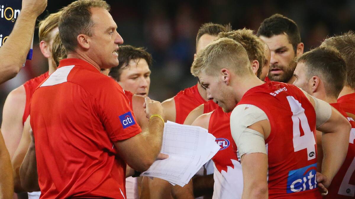 John Longmire, coach of the Swans, speaks to his team as Daniel Hannebery looks on. Picture: Getty Images.