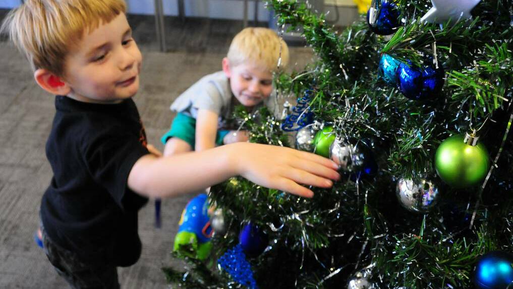 Clayton and Stuart Wheatley check out the Australian Hearing Christmas tree. Photo: GREG KEEN