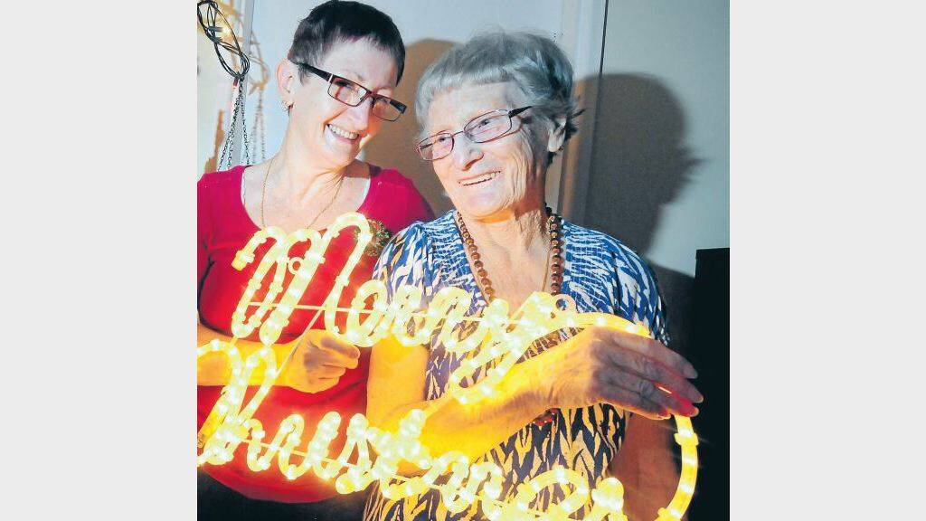 DECEMBER: Sharon Hobson and Marjorie Griffiths hang Christmas lights for the season. Photo: LOUISE DONGES