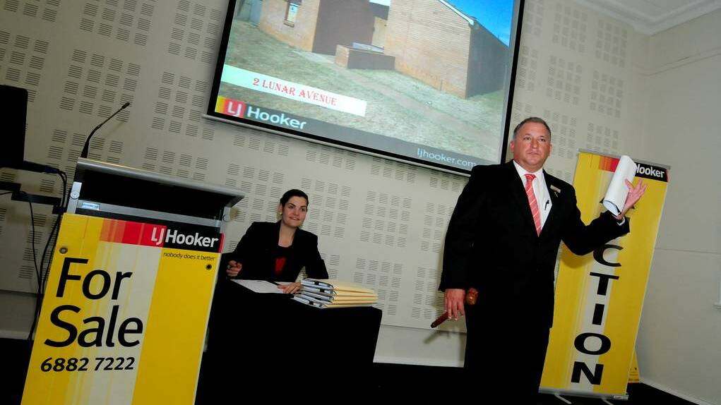 LJ Hooker s Andrew Toole auctioning the last five Apollo Estate properties at the Western Plains Cultural Centre recently. Photo: LOUISE DONGES / FILE