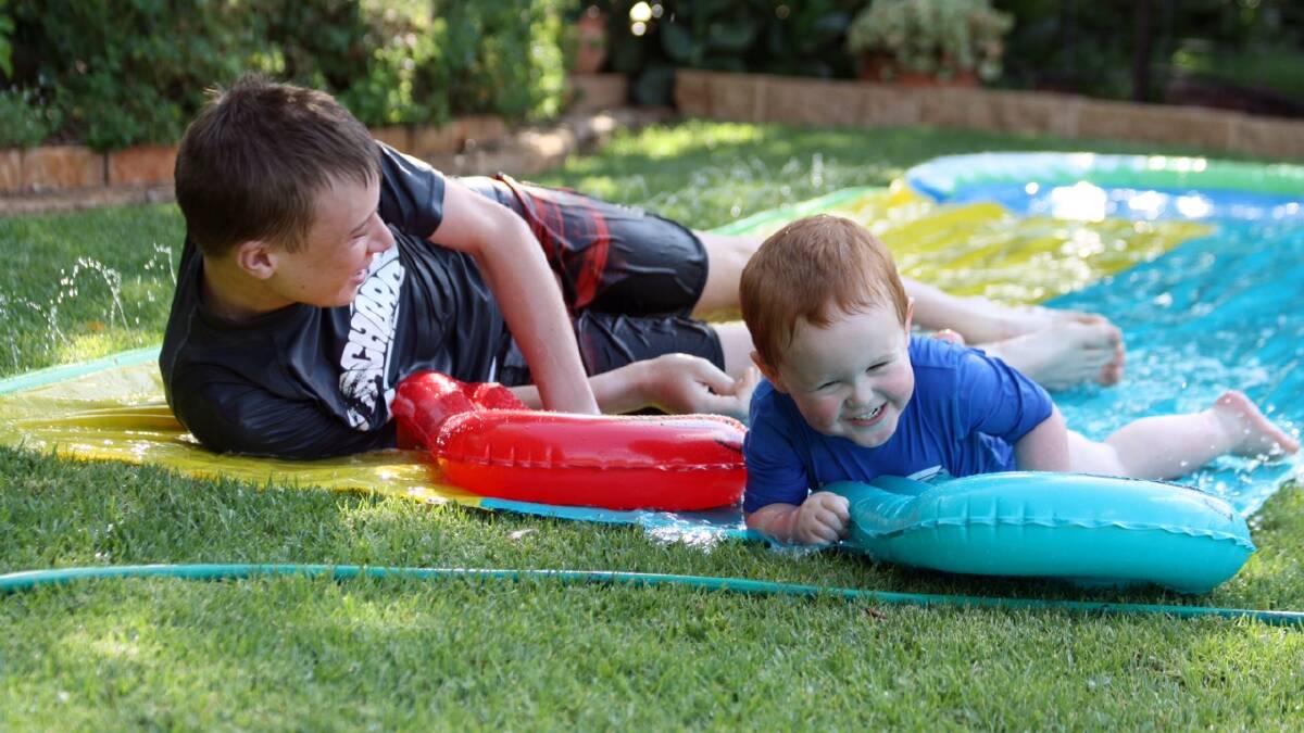Ethan and Beau from Orange loving the water slide in the backyard while spending time with their grandparents in Dubbo during summer. 