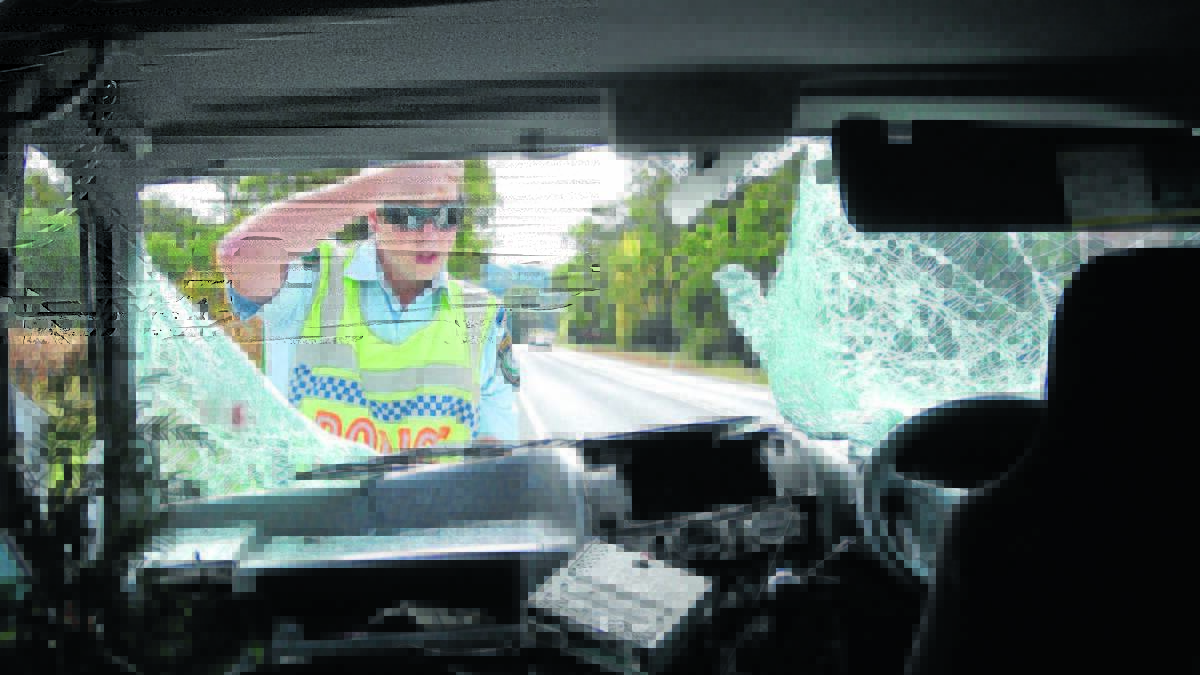 Police officer Trent Bright inspects the damage after a kangaroo cartwheeled through a van on Ulan Road in 2012. The NRMA is urging drivers to take care on the roads, listing Mudgee as the second worst place for animal collisions, while Dubbo is the first. PHOTO: CHRIS CATT / MUDGEE GUARDIAN