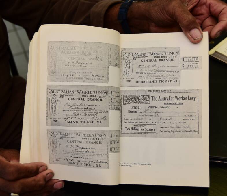 Willie Ferguson holds a book displaying his grandfather's union tickets. 
