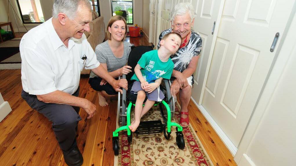 DUBBO: Myles Wilton moves around his home in his new wheelchair to the delight of Pat Yeo, mother Ali Wilton and Barb Kelly.	 Photo: LOUISE DONGES