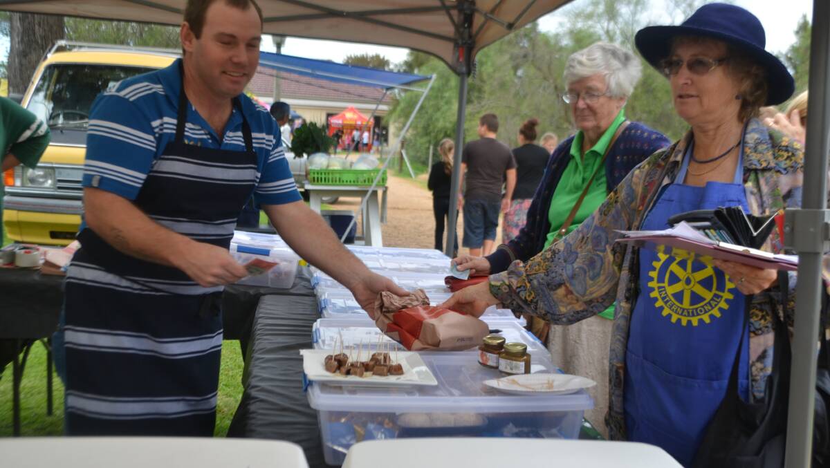 Rodney Dowton is serving Susan Law a meat treat at the markets