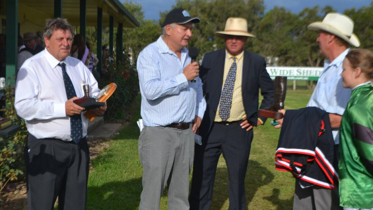 Statewide Shed's Richard Atkins hands Neil Osborne the Wellington Boot 