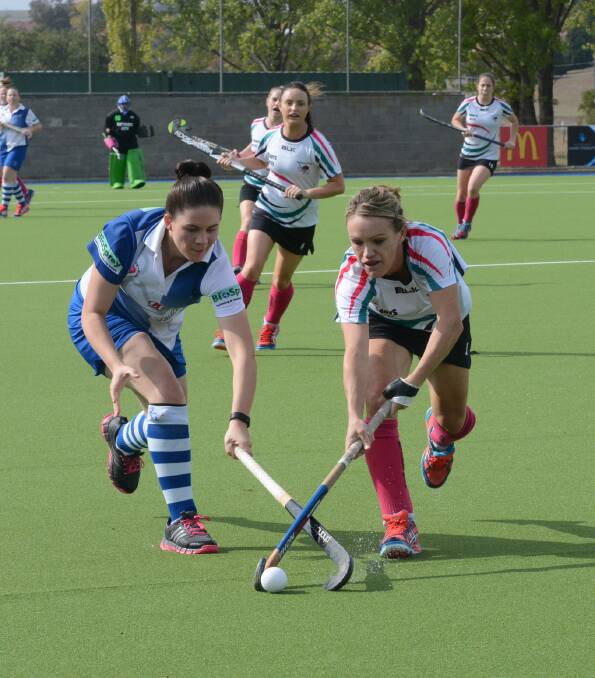 BATHURST BATTLE: Bathurst City player-coach Lisa Quinn  tries to steer the ball clear of the stick of St Pat's rival Cait Hadley in Saturday's women's Premier League Hockey match. Photo: PHILL MURRAY 041616pcity1