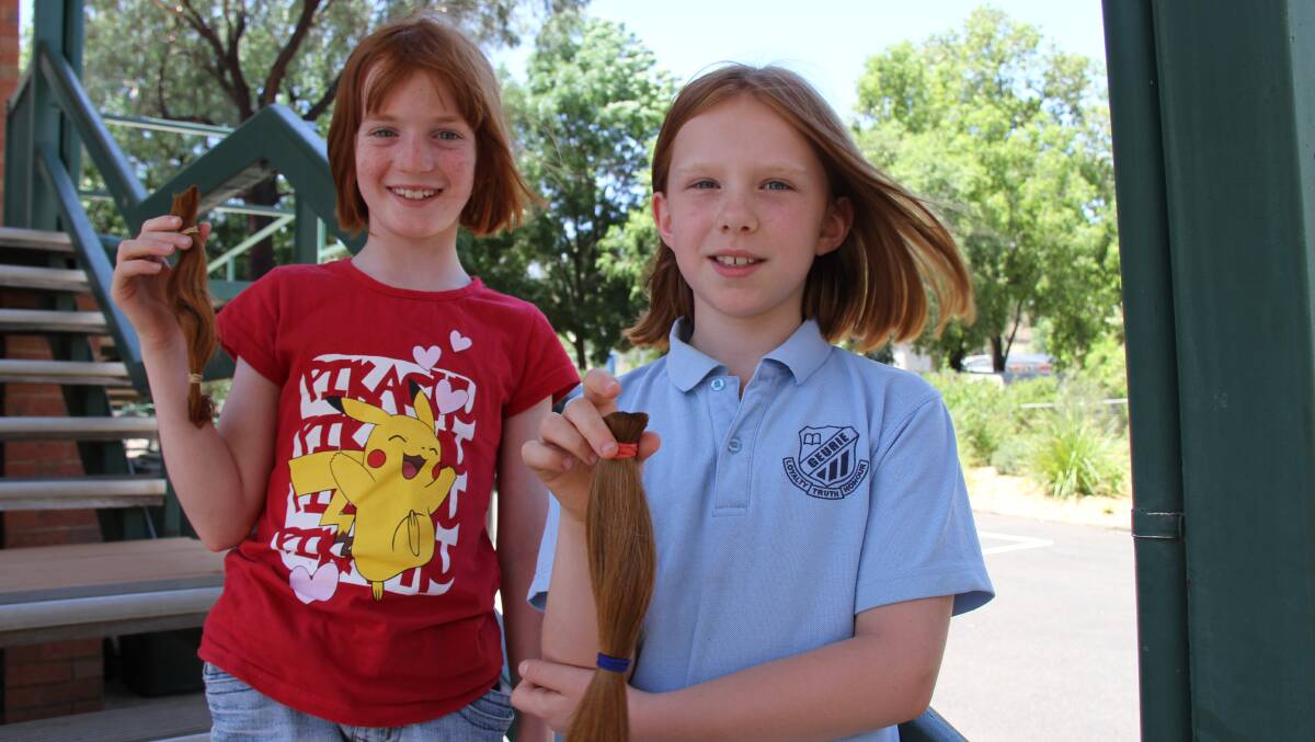 Rose Purcell and Sophie Simpson have donated their hair to a program that makes wigs for women undergoing cancer treatment. Photo: MICHELLE BARKLEY.