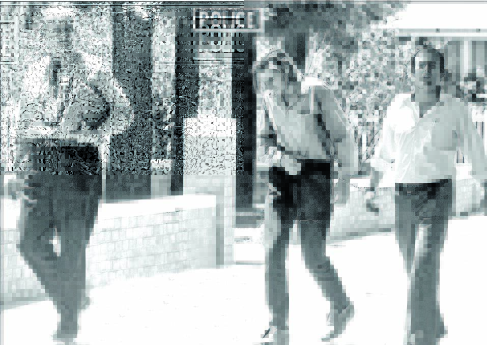 Kevin Crump, centre, is led handcuffed into the Narrabri Court House after his arrest in 1973.