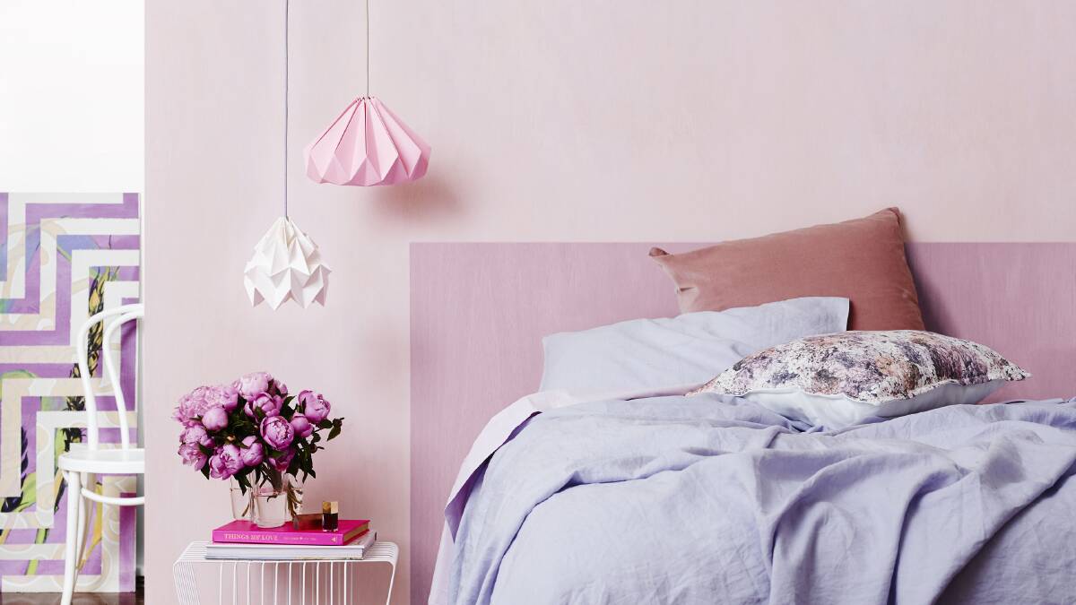 Dulux Bunny Quarter on the walls, Dulux Lilac Fluff marks out a headboard and Peplum Quarter on the ceiling. Photo: Dulux.