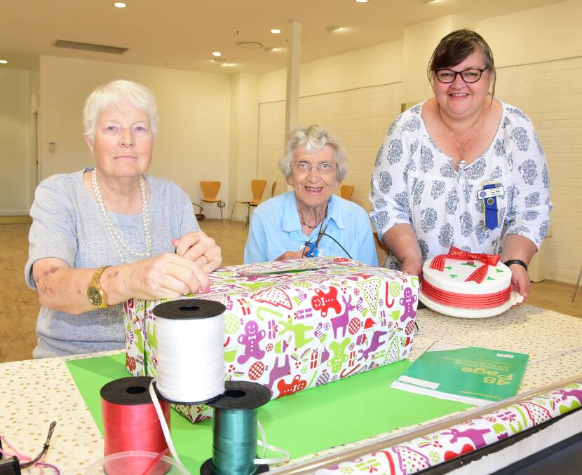 WRAPPED WITH A SMILE: CWA Dubbo's Janet Holloway, Betty Shuttle and Tanya Percy are ready to help those who aren't the best with the wrapping paper at the Chill Out Zone. Photo: BELINDA SOOLE