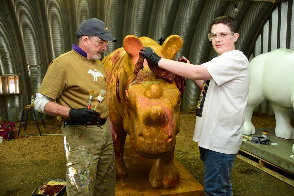 SITE TO SEE: Dubbo artist Jack Randell and 16-year-old William Hazzard painting the welcome rhino last year. Photo: BELINDA SOOLE