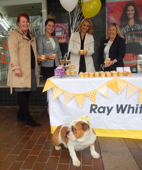 GOOD CAUSE: Ray White Dubbo team Debbie O'Connor, Lauren de Marco, Camille Lyons and Jodie Brightman with Daisy the dog selling cupcakes on Monday for the RSPCA. Photo: ORLANDER RUMING