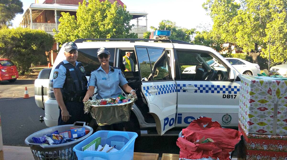 OFFICERS PLAY SANTA: Dubbo police helped St Brigid's Catholic Parish and The St Vincent de Paul Society deliver hampers on Wednesday. Photo: CONTRIBUTED