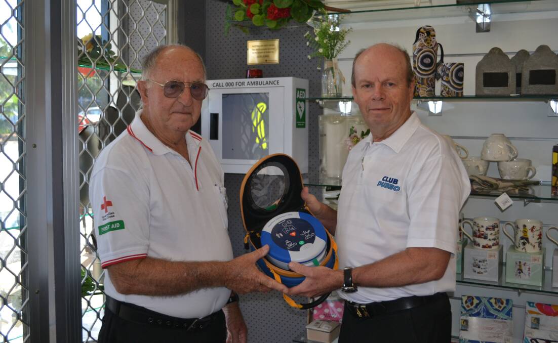 PROGRESS: Australian Red Cross Dubbo first aid trainer George Chapman and Club Dubbo CEO Rod Firth installing one of the defibrillators. Photo: ORLANDER RUMING
