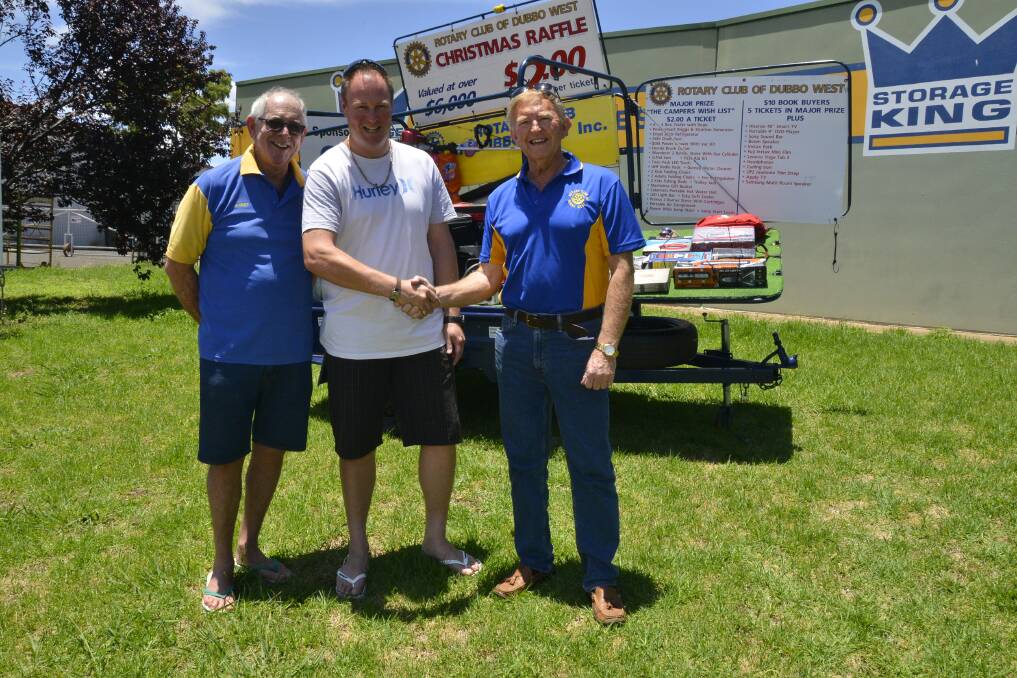 SEALED WITH A SHAKE: Dubbo West rotarians Robert Pfeiffer and Paul Allan congratulating Shane Herron on winning more than $6000 worth of prizes in the raffle. Photo: PAIGE WILLIAMS
