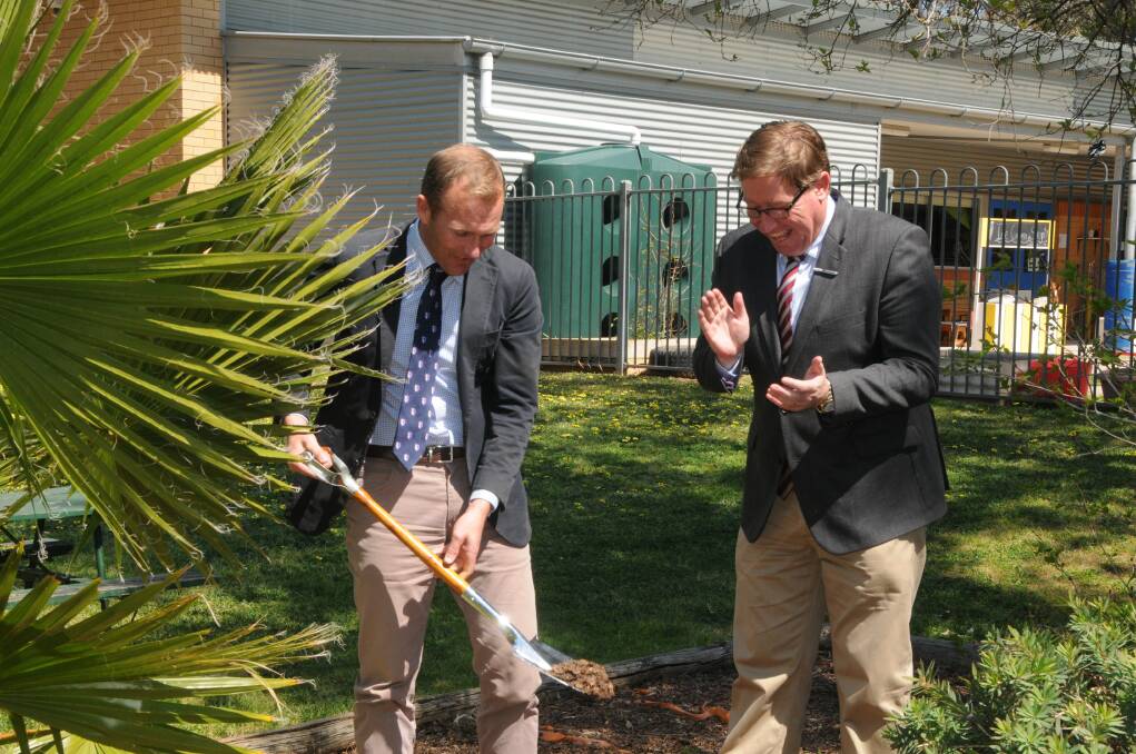 MOMENTOUS: NSW Education Minster Rob Stokes turning the first sod on the site, celebrated by Dubbo MP Troy Grant. Photo: ORLANDER RUMING