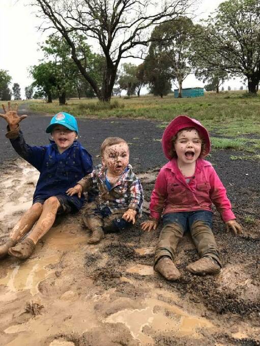 COUNTRY FUN: Four-year-old Tex, 10-month-old Alfie and two-year-old Pearl knew the best thing to do when the rain came down on their farm between Gilgandra and Bourke at the weekend. Photo: CONTRIBUTED