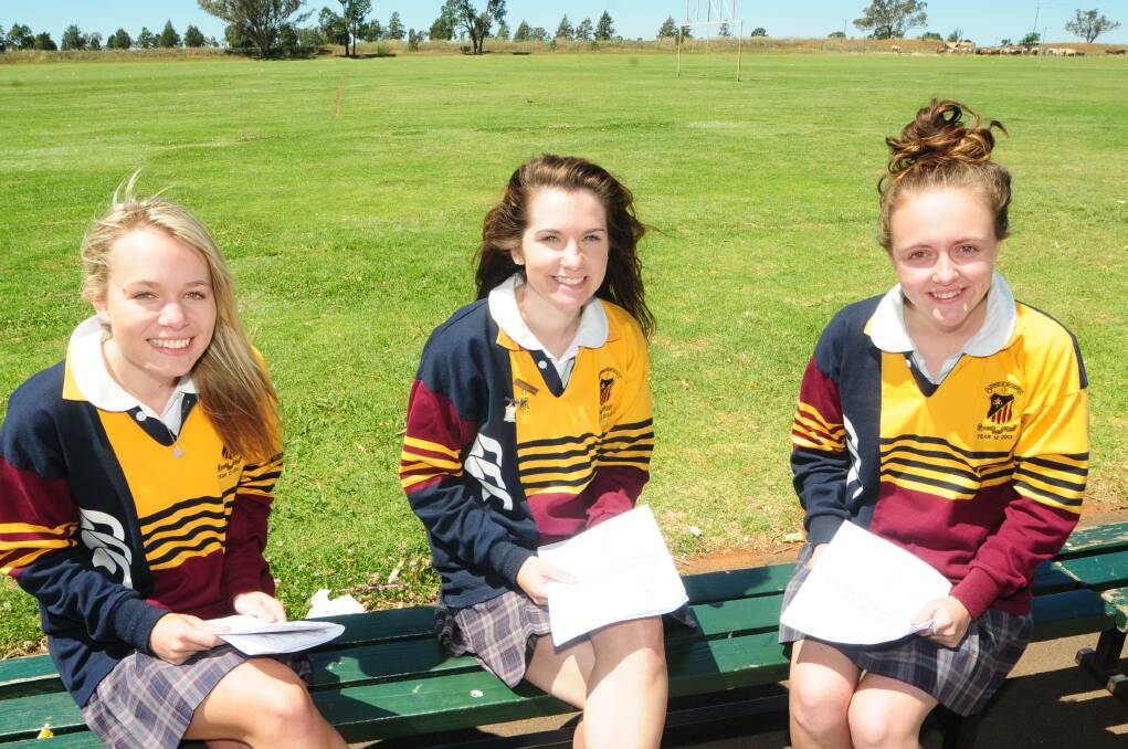 Students Emily Hayes, Amy Armstrong and Belle Haycock review their PDHPE exam paper 
.												PHOTO: CHERYL BURKE