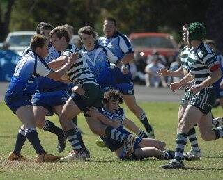Dubbo CYMS powerhouse Max Ray runs into the tackle of Macquarie’s Maddison Thomas and Alan Arnold in the major semi-final played on Sunday.