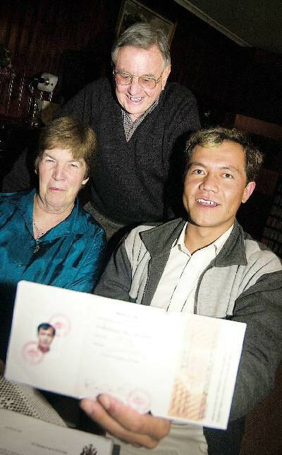 AT LAST: Afghan refugee Hussain Ali Muradi celebrates the arrival of his permanent residency visa with friends Gwen and Bob Young after waiting four years for the precious document.