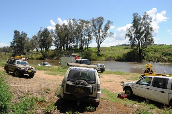 Emergency services crew on the shore of the Macquarie River in Geurie.