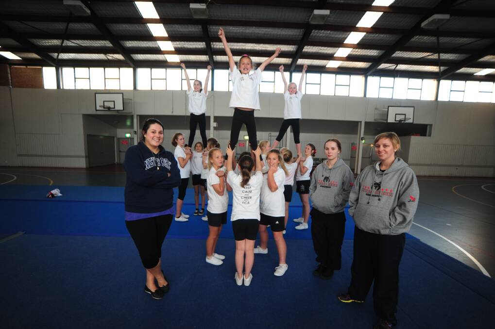 Dubbo Cheer Academy members Hannah Macleod, Mariah Delaney and Paris Wall are held aloft by squad members under the watchful eye of coaches Amy Mawby, Kendy Beasley and Danielle Fistr. 
Photo: BELINDA SOOLE