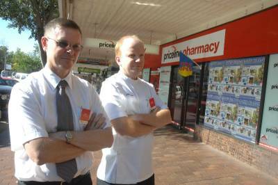NOT IMPRESSED: Mark Rugendyke and Greg Shearing from Priceline Pharmacy who have had their front window smashed for the second time in two weeks.