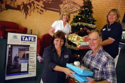 St Vincent de Paul representative Pat Yeo takes delivery of Christmas hampers from Colleen Wall, Virginia Edwards and Chris Whitfield of Dubbo TAFE.