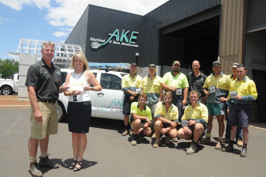 AKE Electrical and Data Installations employees (back) Scott Betts, Damien Taylor, Mick McCaw, Tim Lenord, Nathan Banfield, Des Kidd, Adam Firth and (middle) Joe Simpson, Will Orr and Jake Josephs as Alex Klaassens receives taxi vouchers from Dubbo City Council s Jayne Bleechmore. 		         Photo: AMY McINTYRE