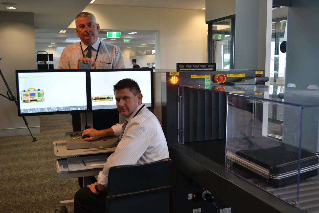 DCC director of corporate development, Ken Rogers and MSS Security trainer, Paul Holiday test the x-ray scanner at Dubbo airport. 	Photo SIMON CHAMBERLAIN