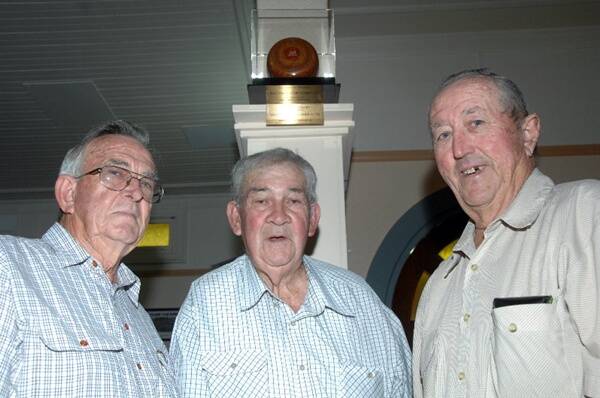 Macquarie men’s bowls president Gordon Taylor (right) with Macquarie Club Ltd president Earl McManus (left) and Ted Madden who designed and made the 50th anniversary trophy that is now mounted on the wall at the club. Macquarie has a triples game on tomorrow to honour the occasion.