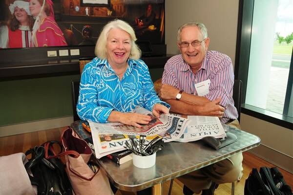 Joan and Rory Treweeke of Angledool Station enjoy reading hard-copy newspapers yesterday during their four-hour wait at Dubbo airport for a flight to Sydney.Photo: AMY MCINTYRE