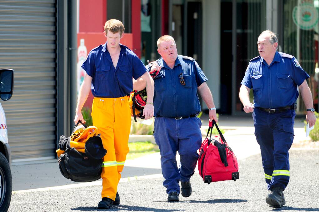 LEFT: 
NSW Rural Fire Service Orana Team operations officer Laurie Douglas (right) farewells David Dugan and Shane Mansfield, deployed in a strike team yesterday to Singleton. 
Photo: LOUISE DONGES.