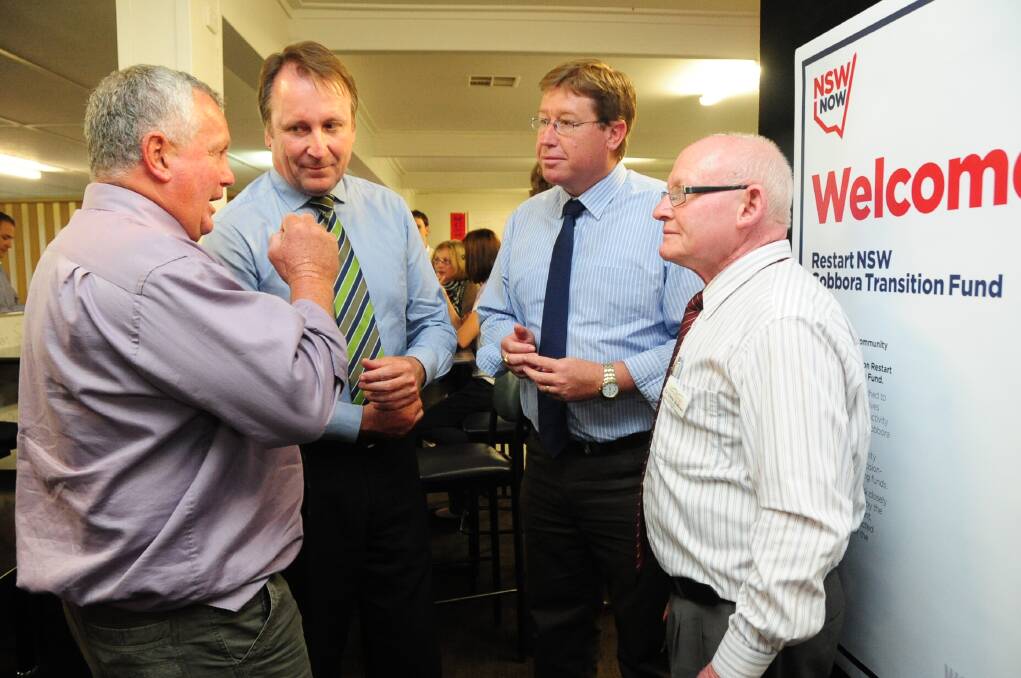 Warrumbungle Shire Council deputy mayor Cr Murray Coe (left) and colleague Cr Chris Sullivan (right) get the ear of Cobbora Transition Committee member Barwon MP Kevin Humphries, and its chairman, Dubbo MP Troy Grant, at the meeting at Dunedoo on October 9. 				   Photo: LOUISE DONGES